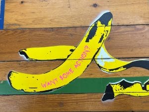 Textilarbeit von Claudia Simon, die mit gesticktem Humor und Upcycling-Materialien bekannte Motive neu interpretiert und Alltagsgegenstände verwandelt.