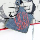 Stencil-Kunstwerk von Claudia Simon mit Batman-Maske und gesticktem Text „Lieb sein“ auf Leinwand, 2024, 53 × 54 cm, Unikat. Nahaufnahme