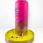 Kunstwerk von Claudia Simon mit pink-goldener Spraydose, Miniaturfiguren und Schriftzug „DON’T QUIT“, unter Glasglocke, Mixed Media 2025.