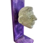 Dennis Thies, „Kopf“, helle Kopfskulptur auf violettem Trägerelement, Mischtechnik, Unikat, 30 × 10 cm, 2006